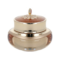  An elegant gold and red container featuring a flower, representing 'The history of whoo Cheonyuldan Hwayul Ultimate Regenerating Cream 60ml'.